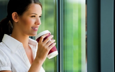 pige-der-drikker-kaffe-stående-ved-vindue